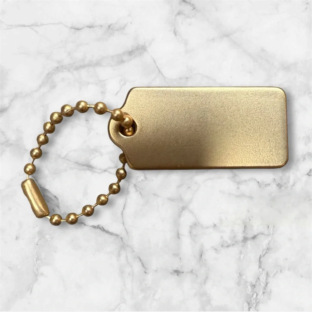 COACH Gold Tag Keychain - COACH New York Signature
